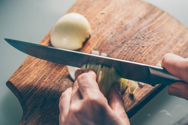 The cook cuts the onion on a cutting board - Foto, Imagen
