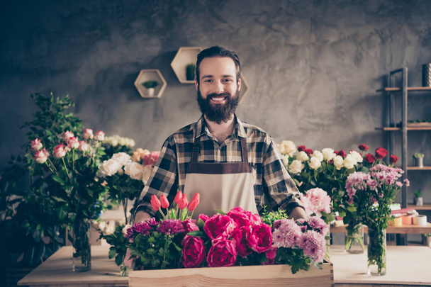 Portrait of his he nice attractive cheery cheerful content guy professional company founder enjoying holding big large box peony tulip diverse at industrial loft concrete style indoors - Fotó, kép