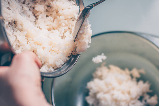 Cook pours boiled rice in a salad bowl - Foto, Imagem