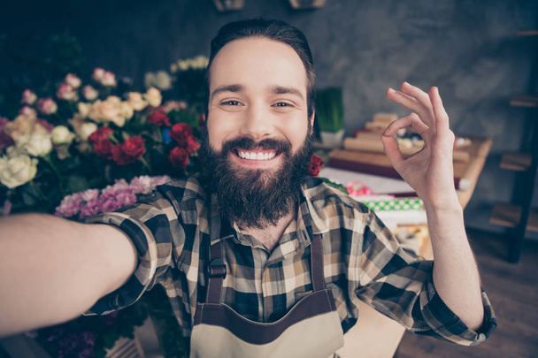 Self-portrait of his he nice attractive content cheerful cheery glad positive guy enjoying life showing ok-sign cool good wearing checked shirt at modern industrial loft concrete style salon indoors - Фото, изображение