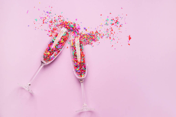 Bicchieri con coriandoli su sfondo colore
 - Foto, immagini