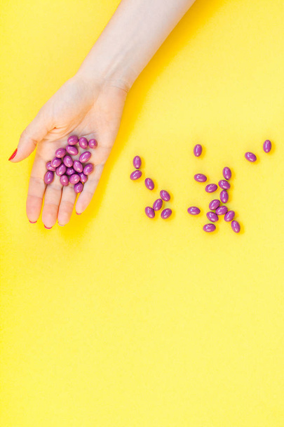 Woman hand holding purple pills handful - Фото, зображення