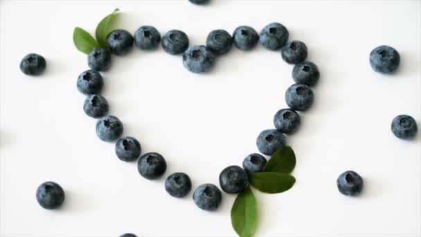 Lato Blueberry serce rama detox na białym tle. Miłość jagody projekt granicy. Zamknij widok z góry lub płaski lay z miejscem na tekst - Materiał filmowy, wideo