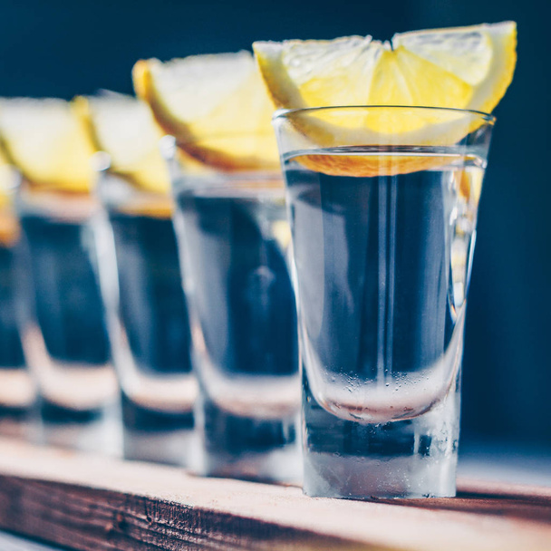 The barman serves a glass of vodka and lemon on the board - Φωτογραφία, εικόνα