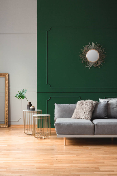 Sun shape mirror on empty green wall in stylish living room interior - Foto, afbeelding
