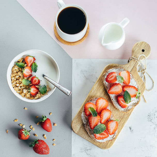 Gezond ontbijt concept. Toast met kwark en aardbei, yoghurt met granola en kopje koffie over Tricolor stijlvolle achtergrond, bovenaanzicht, vlakke lag. Gezondheid, gewichtsverlies, dieetvoeding concept - Foto, afbeelding