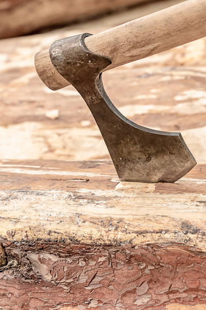 AX zwarte oude smalle gebogen Blade close-up achtergrond houten rustieke traditionele bouw - Foto, afbeelding