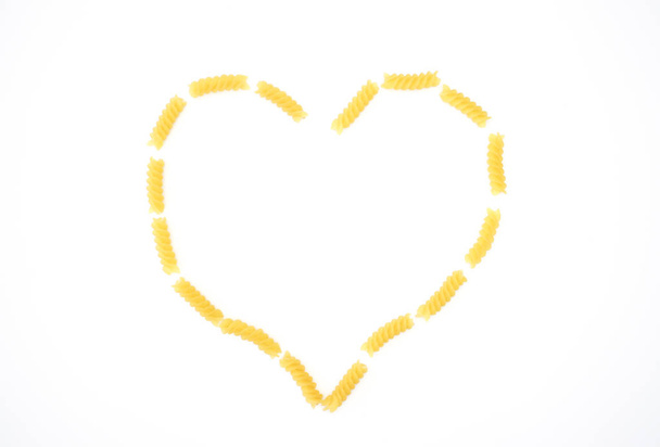 Heart from fusilli pasta on white background  - Foto, Imagen