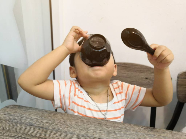 幸せな小さな男の子は、日本のレストランでおいしい味噌汁を食べて楽しんでいます. - 写真・画像