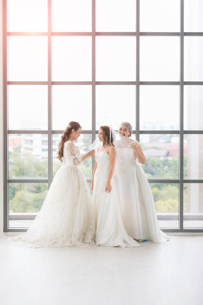 Groupe de belles mariées organiser leur robe
 - Photo, image