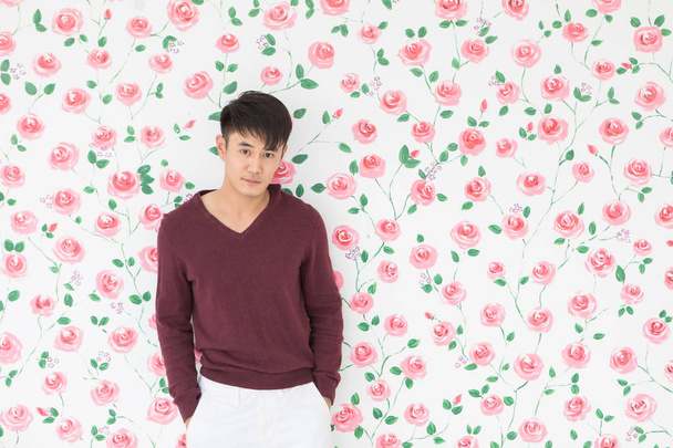 Asiatique homme debout, posant sur fond floral
 - Photo, image