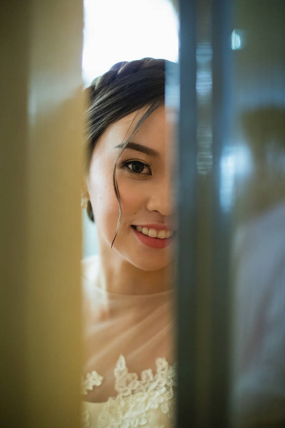 Невеста заглянула в дверь в день своей свадьбы
 - Фото, изображение