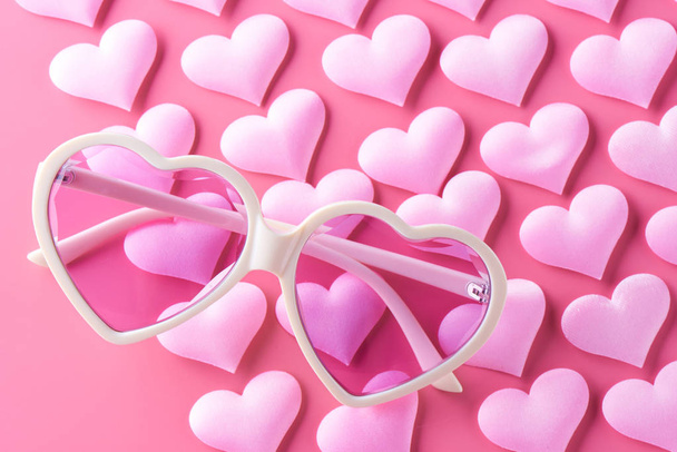 Glasses in the shape of hearts on a pink background. Concept of naive love - Photo, Image