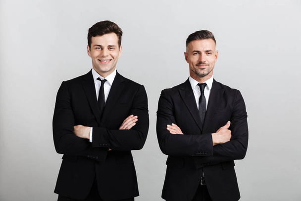 Two attractive confident businessmen wearing suits - Фото, изображение