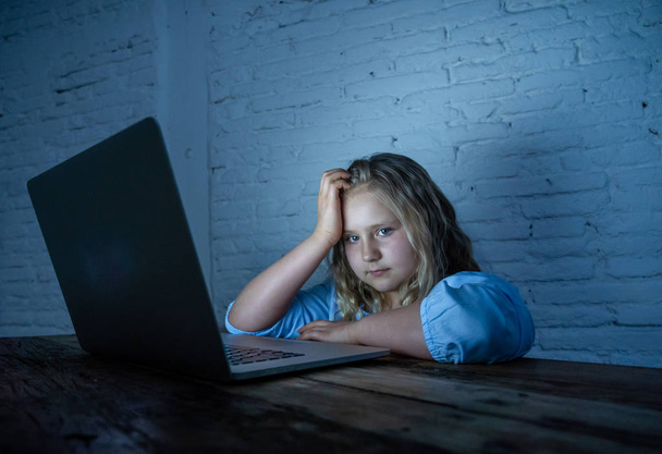 Scared sad girl bullied on line with laptop suffering cyber bullying harassment feeling desperate and intimidated. Child victim of bullying stalker social media network and the dangers of internet. - Photo, Image