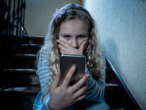 Sad depressed girl Bullied by text message humiliated online social media by classmates. Sad depressed young girl victim of cyberbullying by mobile phone sitting on stairs feeling lonely hopeless. - Foto, immagini