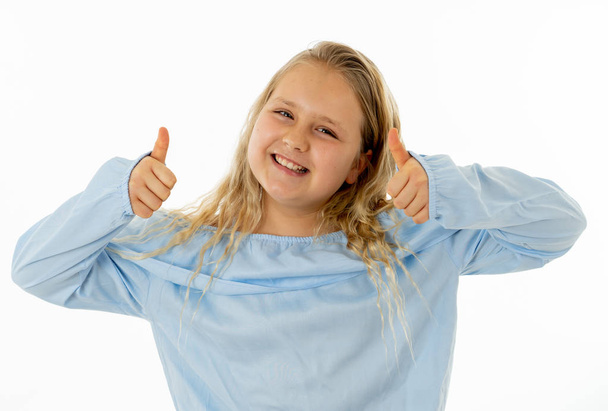 Portrait of young schoolgirl feeling happy smiling and making thumbs up gesture. Isolated on neutral background. In Education Children, Human expressions and body language. - Photo, image