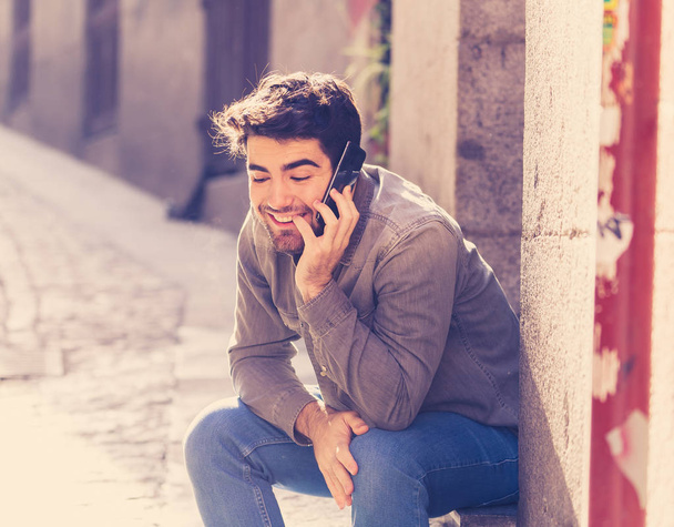 Young happy man in his twenties on mobile phone talking and chatting with friends on social media app on holidays in Europe. In communication, Traveling, technology internet and lifestyle concept. - Foto, Bild