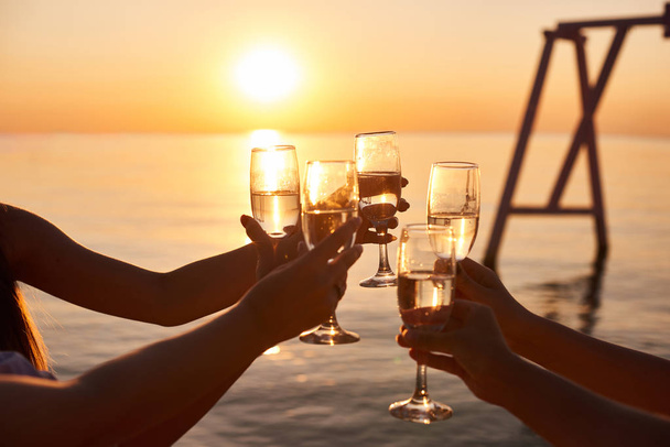 slepičí párty před svatbou. dívky v letovisku relaxují. brzy ráno přátelé pijí šampaňské a setkají se s úsvitem na moři - Fotografie, Obrázek