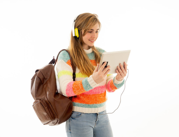 Portrait of happy young teenager student woman in headphones using tablet watching a video tutorial online curse or listening to music. Isolated white background. In technology and student lifestyle. - Fotó, kép