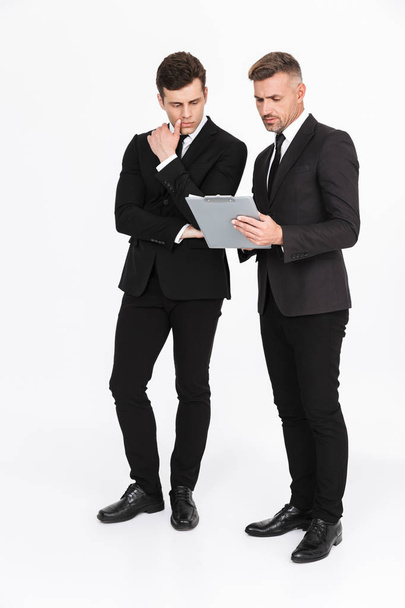 Two attractive confident businessmen wearing suits - Fotó, kép