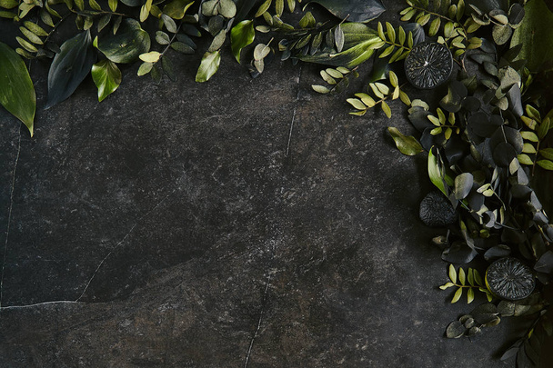 Dark green tropical leaves mockup on natural black stone backgro - Foto, Imagen