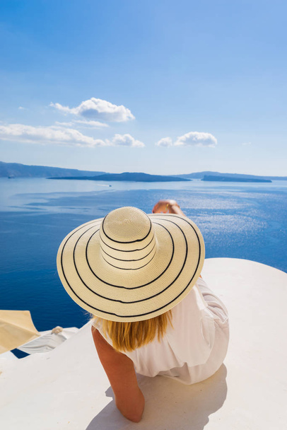 Luxury travel vacation woman looking at view on Santorini island - Foto, afbeelding