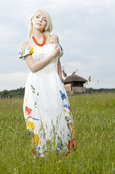 Young rural woman standing at the green field - Fotografie, Obrázek