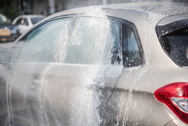 Чистка автомобиля с использованием воды высокого давления на открытом воздухе
. - Фото, изображение