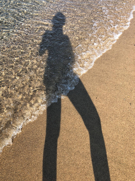 egy nő tükörképe a homokos strandon - Fotó, kép