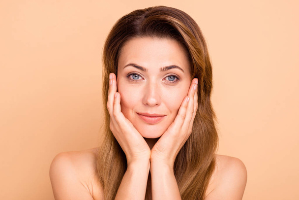 Close up photo beautiful amazing mature she her lady hold hands arms cheeks cheekbones show great got much younger facial skin result anti-age mask procedures nude isolated pastel beige background - Фото, зображення