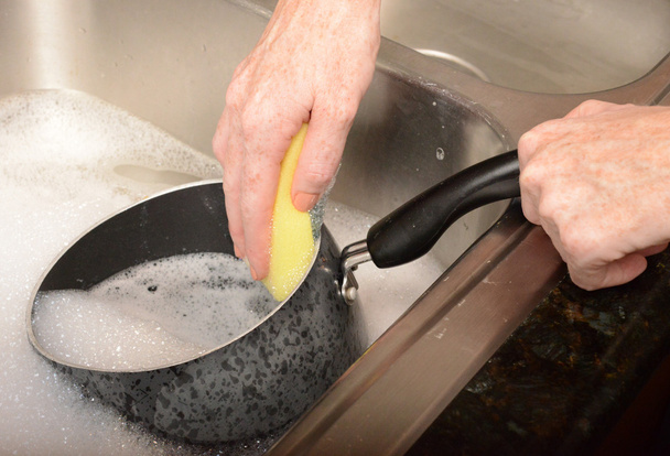 fregar olla mientras se lavan los platos
 - Foto, Imagen
