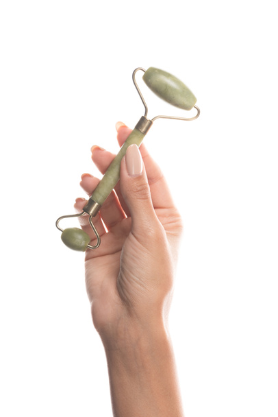 cropped view of woman holding facial jade roller isolated on white - Fotoğraf, Görsel