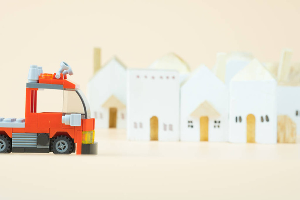 Fire truck plastic toy with village background. - Photo, Image