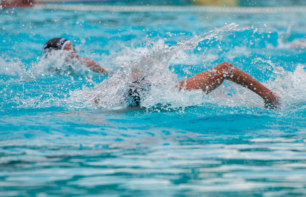 Спортсмени плавають вільним стилем на басейні
 - Фото, зображення