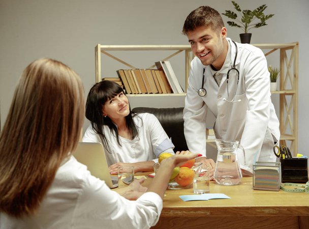 Smiling nutritionists showing a healthy diet plan to patient - Zdjęcie, obraz