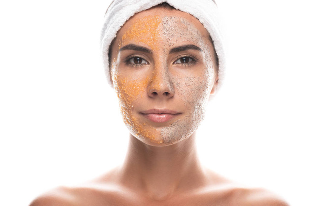 Vorderseite der jungen Frau in kosmetischen Haarband mit Peeling im Gesicht isoliert auf weiß - Foto, Bild
