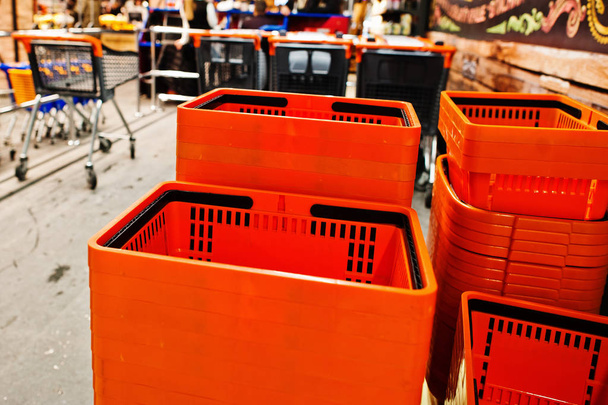 Orange plastic shopping baskets on supermarket. - Photo, Image