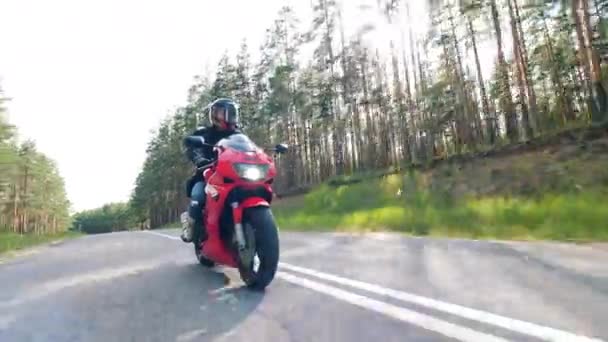 Motorradfahrer rast mit seinem Motorrad. Asphaltstraße mit Biker am Steuer eines Motorrads - Filmmaterial, Video