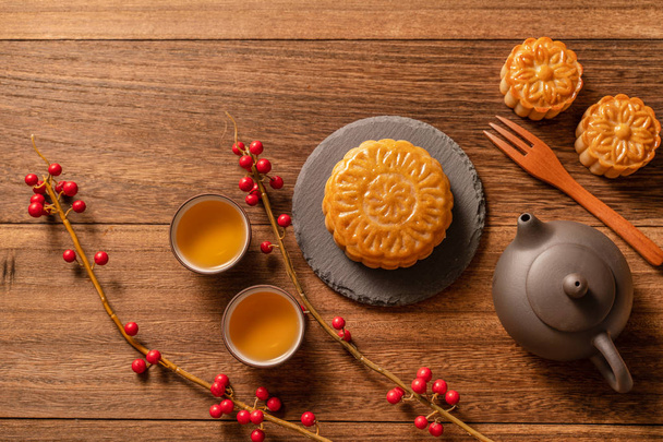 Moon cake Mooncake table setting - Chinese traditional pastry with tea cups on wooden background, Mid-Autumn Festival concept, top view, flat lay. - Photo, image