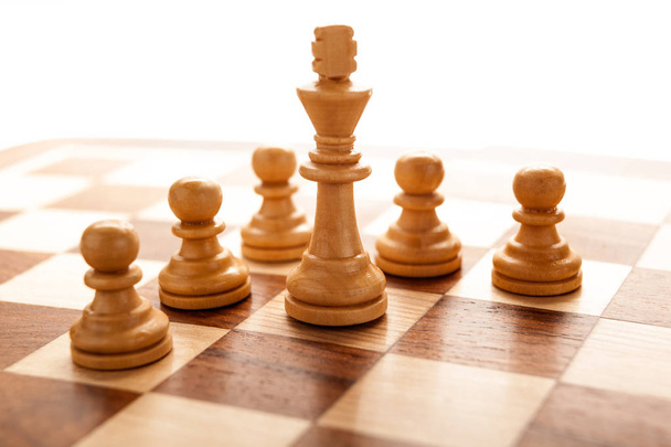 Pièce d'échecs du roi blanc entourée de pions
 - Photo, image