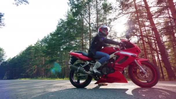 Kierowca siedzi na czerwonym motocyklu - Materiał filmowy, wideo