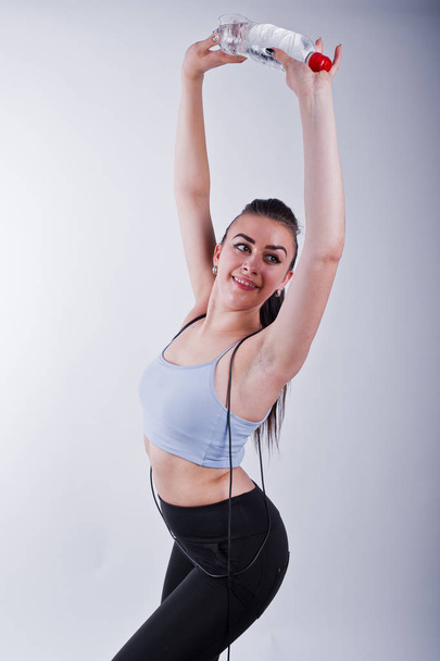 Vrolijke aantrekkelijke jonge fitness vrouw in top en zwarte legging - Foto, afbeelding