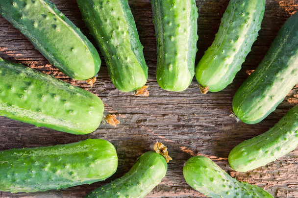 Fresh organic cucumbers on the old wooden background - Photo, Image