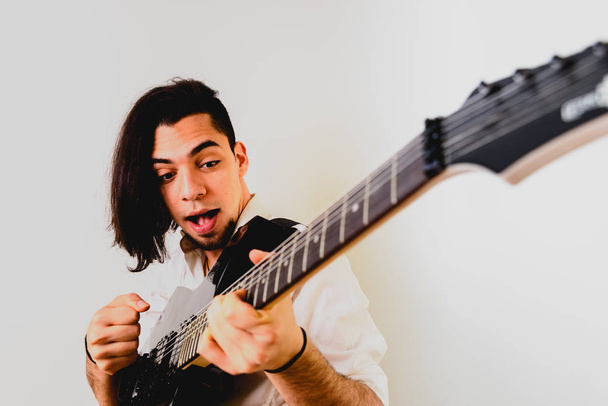 Guitarist posing with his electric guitar, white background. - Foto, Imagem