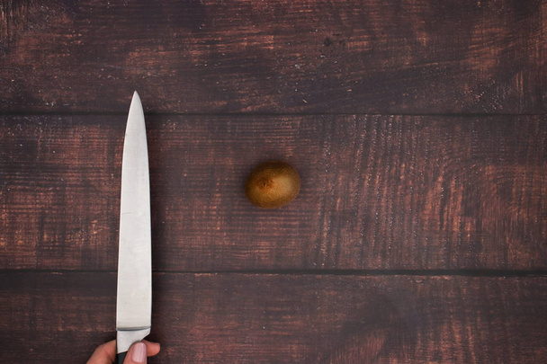 Knife cut fresh kiwi on the wooden table  - Zdjęcie, obraz