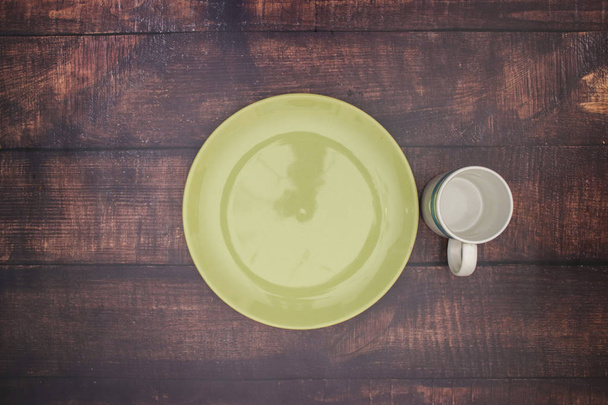 Empty green plate and cup on the table  - Фото, зображення