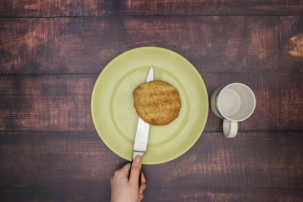 Knife cut bread on the green plate and cup on the table  - Fotoğraf, Görsel
