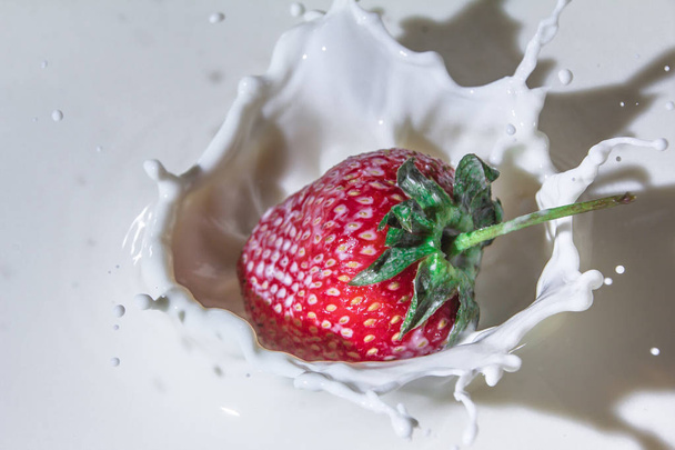 Juicy strawberry flavor. Splashes of milk. Freshness of summer. Fruits. Fruit freshness. Berries. Still-life. Strawberries are like an explosion of taste. Strawberries and cream. Red berry on white background. - Fotoğraf, Görsel