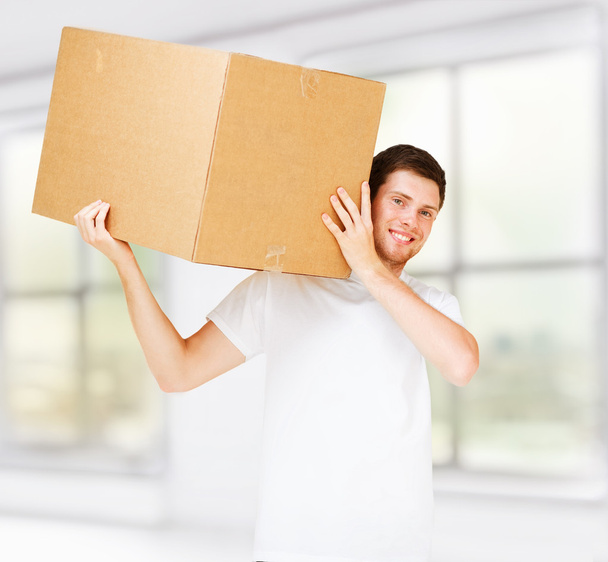 Smiling man carrying carton box - Photo, Image